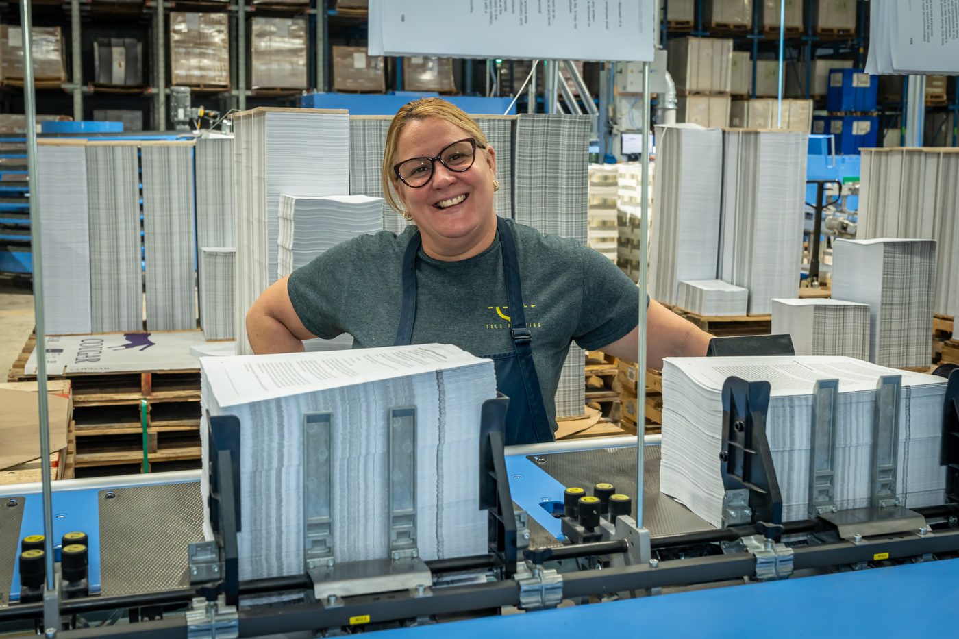 Solo Printing operator with finished magazines on the bindery line in Miami